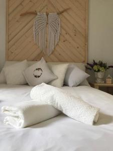 a white bed with white pillows and a wooden headboard at Gorczańska Chatka in Osobie +78 photos