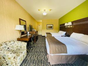 a hotel room with two beds and a chair at Fernie Stanford Resort in Fernie