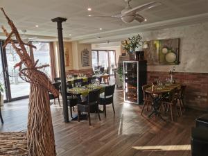a restaurant with tables and chairs in a room at Suites Conviviales la Vignette in Benfeld