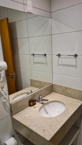 a bathroom with a sink and a mirror at Condomínio Barretos Thermas Park - Flat Parque do Peão in Barretos