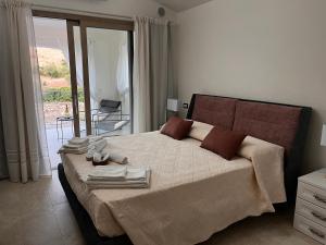 a bedroom with a large bed with towels on it at LAMEFATA in San Teodoro