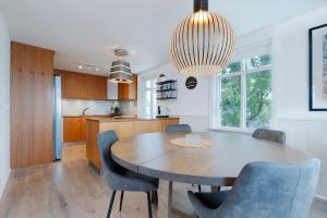 cocina y comedor con mesa de madera y sillas en V13 Guesthouse, en Keflavík