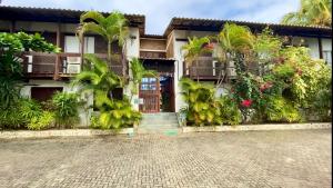 una casa con palmeras y una entrada de ladrillo en Hotel - Pousada-Zen Bougainville, en Salvador