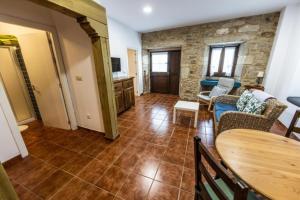 - un salon avec un mur en pierre, une table et des chaises dans l'établissement Apartamentos Arnela, à Camariñas