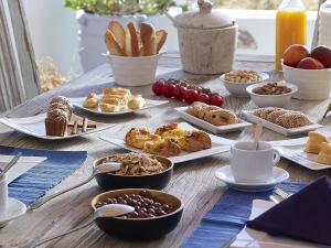 a wooden table with plates of food on it at Artemis Seaside Resort in Paliochori
