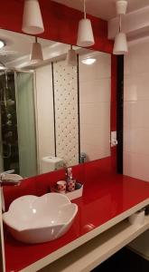 a bathroom with a red counter with a sink at Wiolinkowo in Sarnaki