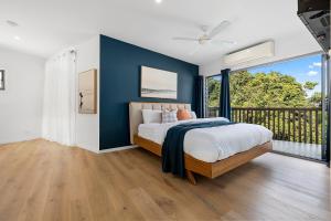 1 dormitorio con 1 cama con pared azul en Papillon Coolum, en Coolum Beach