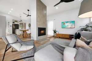 a living room with a couch and a fireplace at Papillon Coolum in Coolum Beach