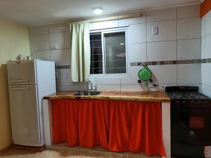 Una cocina con un refrigerador blanco y un fregadero. en Rayo Solar Depto Rama Caída, en San Rafael 5 fotos más