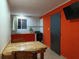 cocina con mesa de madera y TV en la pared en Rayo Solar Depto Rama Caída en San Rafael