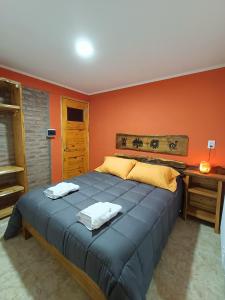 1 dormitorio con 1 cama azul grande y paredes de color naranja en Rayo Solar Depto Rama Caída, en San Rafael
