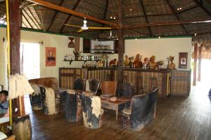 Cette chambre comprend un bar avec des chaises. dans l'établissement Les bungalows d'Ambonara, à Hell-Ville