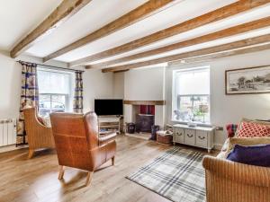 ein Wohnzimmer mit Sofa und Fernseher in der Unterkunft Magnolia Cottage in Barton