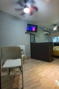 Habitación con silla y TV en el techo. en R.1109 Estudio ejecutivo., en Panamá