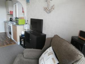 a living room with a couch and a flat screen tv at Beautiful 2-Bed Chalet in Mablethorpe in Mablethorpe