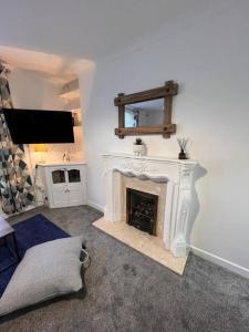 a living room with a fireplace and a tv at Bridge Place - Spacious home with plenty of beds! in Merthyr Tydfil