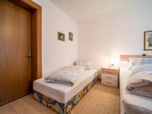 1 dormitorio con 2 camas individuales y puerta de madera en Apartment Claudia en Vandans