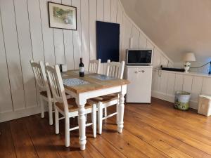 een eetkamer met een tafel en stoelen en een koelkast bij Bed & Breakfast De Koegang in Zuidermeer
