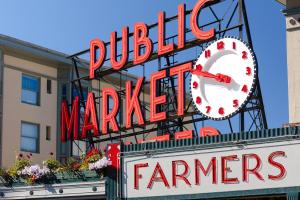 una señal que lee a los granjeros del mercado público con un reloj en él en Sonder at Pivot en Seattle