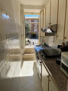 uma cozinha com um lavatório, um micro-ondas e uma janela em Appartamento esclusivo nella piazza di Numana em Numana
