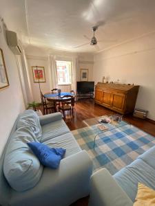 a living room with a blue couch and a table at Appartamento esclusivo nella piazza di Numana in Numana