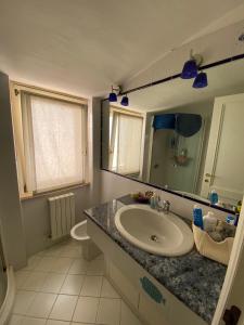 W łazience znajduje się umywalka i lustro. w obiekcie Appartamento esclusivo nella piazza di Numana w mieście Numana