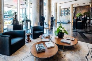 a lobby with two tables and chairs and people at SLS Buenos Aires Puerto Madero in Buenos Aires