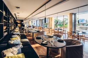 a restaurant with couches and tables and windows at SLS Buenos Aires Puerto Madero in Buenos Aires