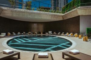 a large swimming pool with chairs in a building at SLS Buenos Aires Puerto Madero in Buenos Aires