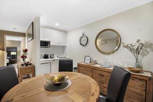 a kitchen and dining room with a wooden table and chairs at Villa 3 By The Sea in Coffs Harbour