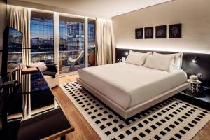 a bedroom with a large bed and a large window at SLS Buenos Aires Puerto Madero in Buenos Aires