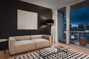 a living room with a couch and a large window at SLS Buenos Aires Puerto Madero in Buenos Aires