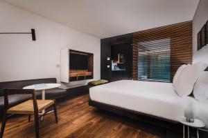 a bedroom with a bed and a table and a tv at SLS Buenos Aires Puerto Madero in Buenos Aires