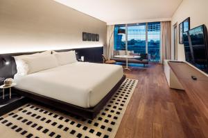 a bedroom with a large bed and a living room at SLS Buenos Aires Puerto Madero in Buenos Aires