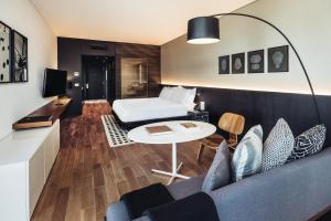 a room with a bed and a couch and a table at SLS Buenos Aires Puerto Madero in Buenos Aires