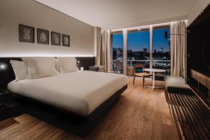 a bedroom with a bed and a view of a city at SLS Buenos Aires Puerto Madero in Buenos Aires