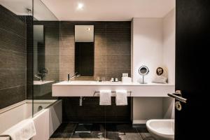 a bathroom with a sink and a toilet and a mirror at SLS Buenos Aires Puerto Madero in Buenos Aires