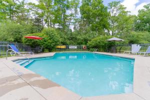 een groot blauw zwembad met stoelen en een parasol bij Westover Inn in Saint Marys