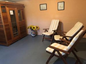 two rocking chairs in a room with a vase of flowers at Vast Holiday Home in Frankenau with Infrared Sauna in Frankenau