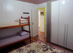 1 dormitorio con litera y puerta que da a un pasillo en Casa de Ferias Alternativa, en Urubici