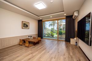 a living room with a table and a large window at Jeju Arumdaun Resort in Seogwipo