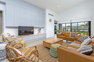 a living room with a couch and a tv at Allure in Port Fairy