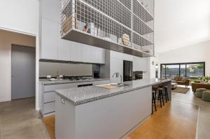 a kitchen with white cabinets and a counter top at Allure in Port Fairy