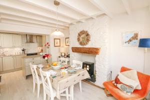 a kitchen and dining room with a table and a fireplace at The Shell Seekers in Fowey