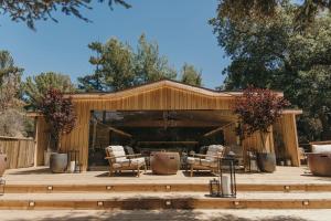 a wooden pavilion with two chairs on a wooden deck at Calamigos Guest Ranch and Beach Club in Malibu