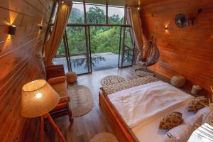 a bedroom with a bed and a large window at Tea Cabins in Ella