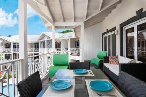 un patio con divano e sedie sul balcone. di Private Condo on the West Coast of Barbados a Saint James