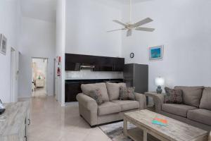 Sala de estar con 2 sofás y mesa en Private Condo on the West Coast of Barbados en Saint James
