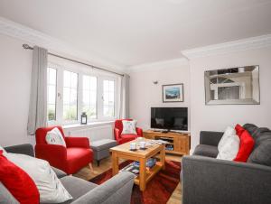 a living room with two couches and a tv at Mews Cottage in Menai Bridge