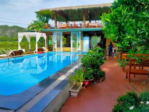 a resort with a swimming pool and a house at Tam Coc Wonderland Bungalow in Ninh Binh